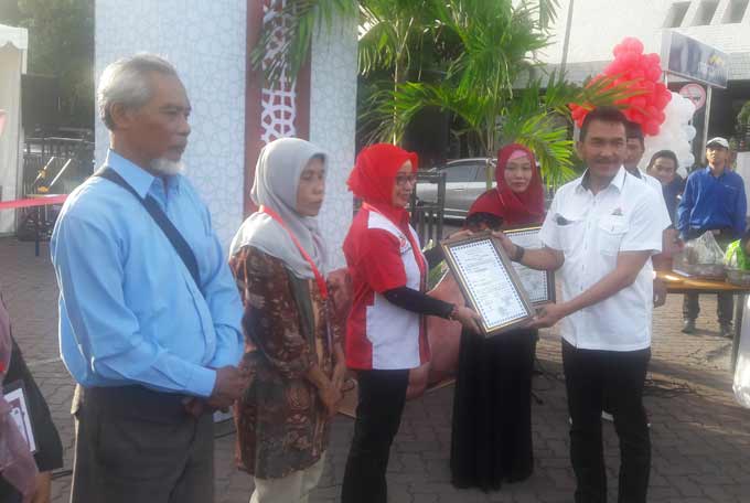 Kepala Departemen CSR Semen Indonesia, Wahjudi Heru saat menyerahkan sertifikat halal.