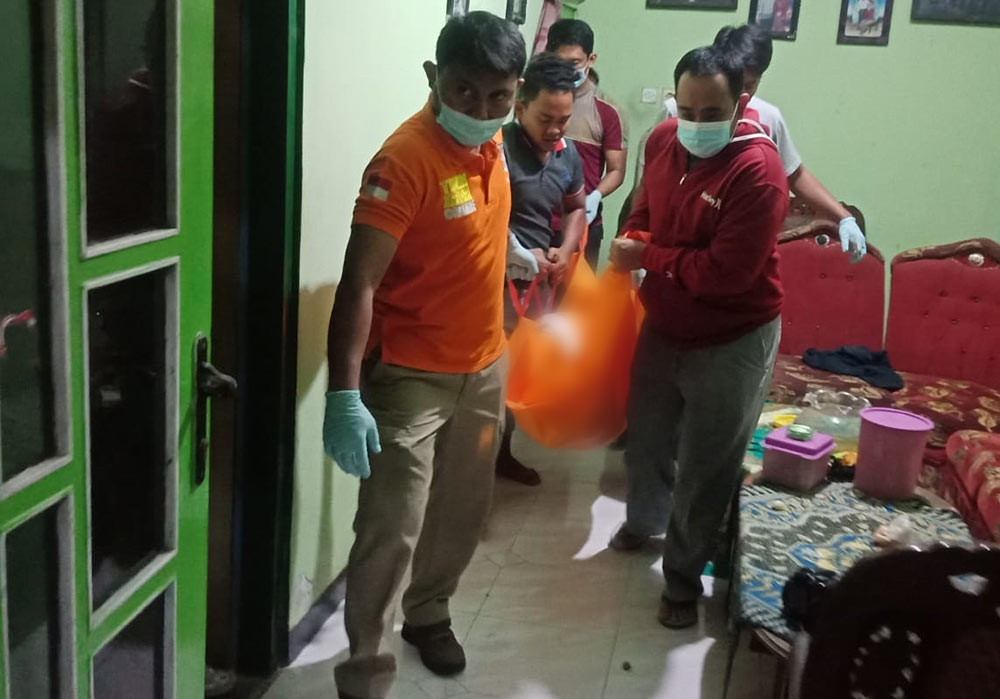 Petugas saat mengevakuasi jenazah tukang jamu di Blitar.