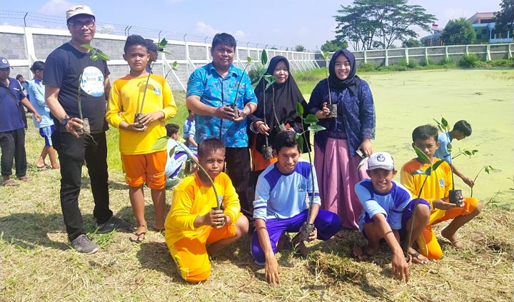 Wakil Kepala SMPN 18 Surabaya Hadi Sanusi didampingi Kepala Perpustakaan Sulastri serta Koordinator Komunitas Nol Sampah Hermawan Some, sedang bersiap menanam bibit mangrove. foto: YUDI A/ HARIAN BANGSA