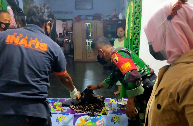 Petugas saat memeriksa mayat si jabang bayi yang dibuang ibu kandungnya. (foto: Ist.)