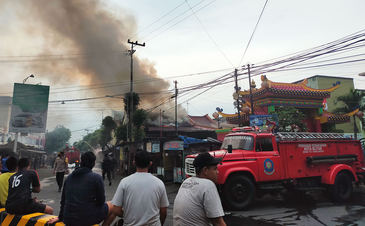 Asap tampak membumbung tinggi dari dari Kelenteng Poo An Kiong yang Terbakar. foto: AKINA/ BANGSAONLINE