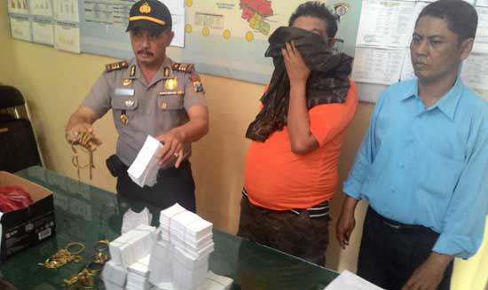 Tersangka berikut barang bukti tumpukan kertas saat diamankan di Mapolsek Gampengrejo, Kabupaten Kediri. foto: dendi martoni/BANGSAONLINE