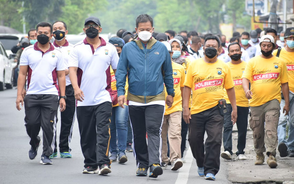 Kapolresta Sidoarjo Kombes Pol Kusumo Wahyu Bintoro (jaket biru) saat jalan sehat bersama para wartawan (kaos kuning).