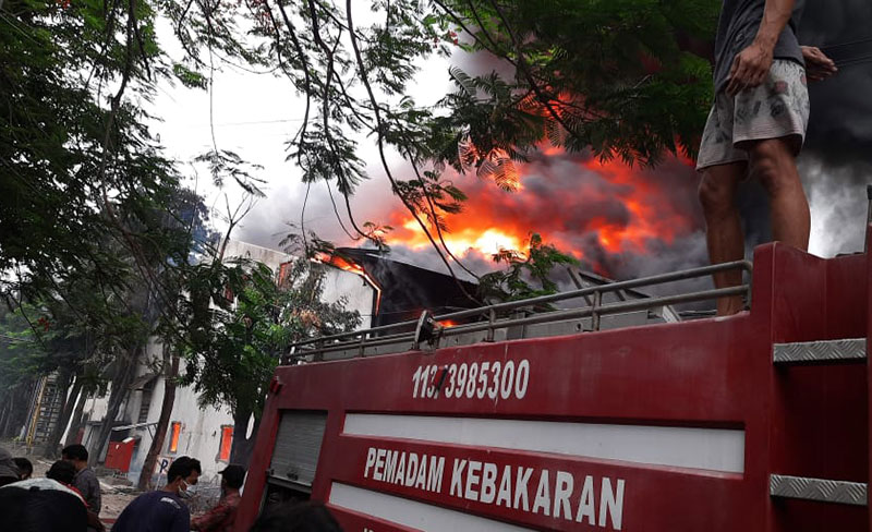 Tim pemadam kebakaran sedang berjibaku melawan kobaran api di gudang produksi PT Panjimas Textile. Foto: Ist