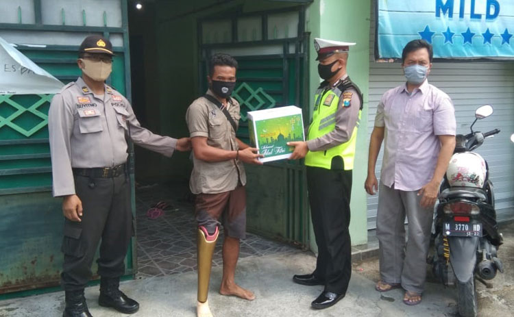 Personel Polres Bangkalan menyerahkan bantuan sembako kepada salah satu disabilitas.