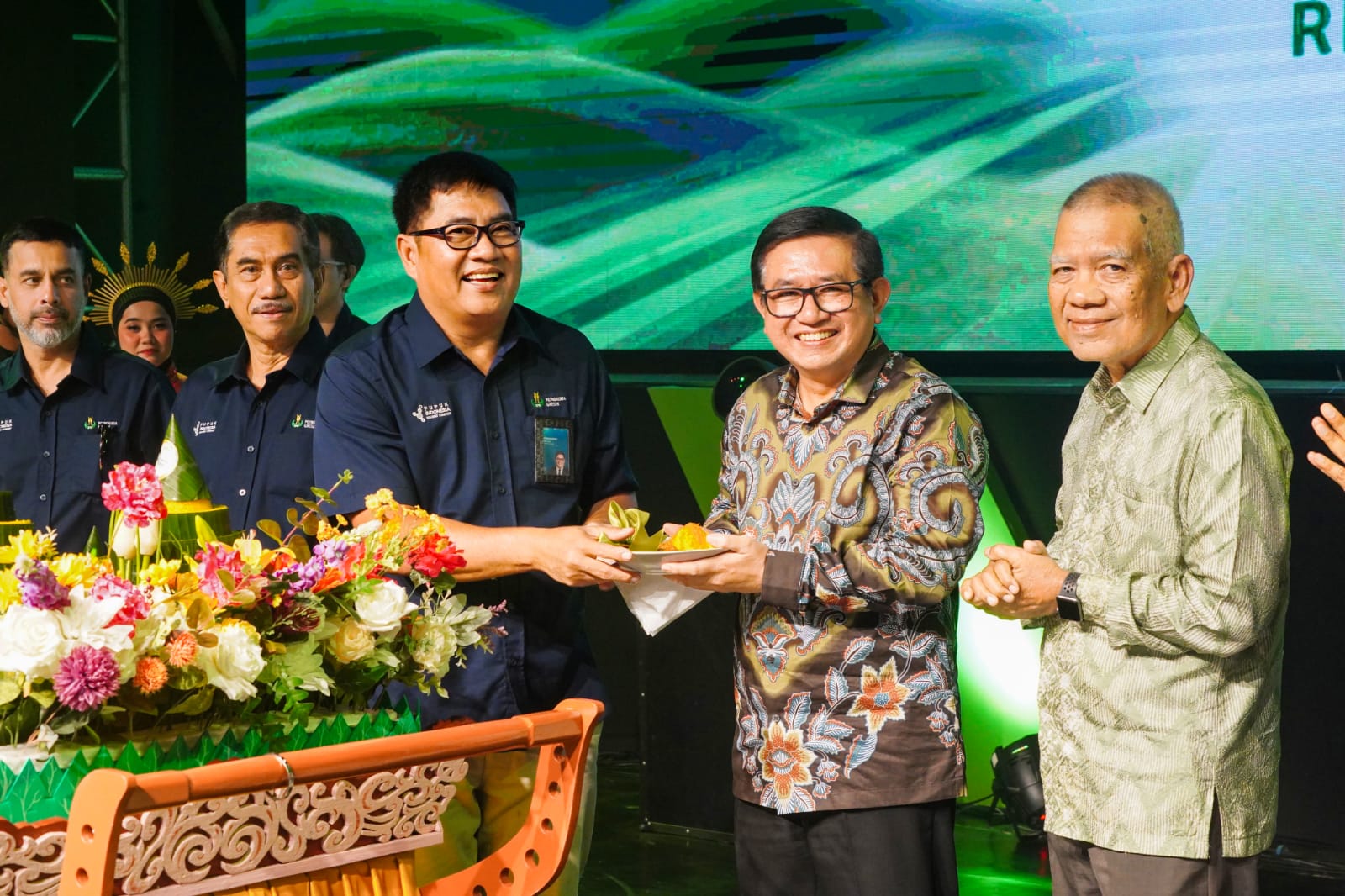Dirut Petrokimia Gresik Daconi Khotob (tiga dari kiri) menyerahkan potongan tumpeng kepada Direktur Operasional PT PI Dwi Satriyo Annurogo saat tasyakuran HUT ke-53 Petrokimia Gresik. Foto: Ist.