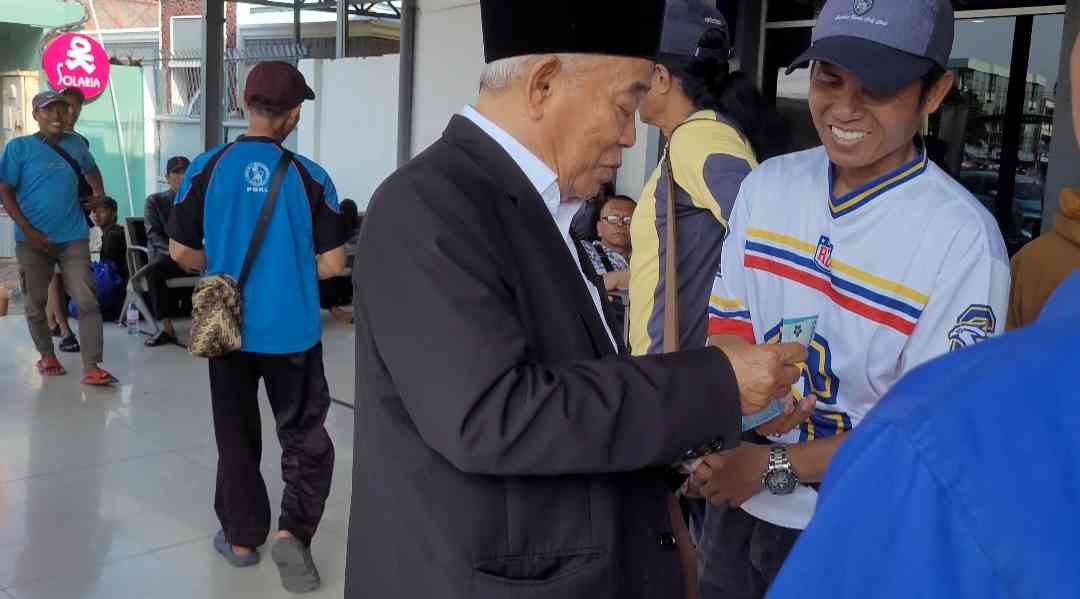 Prof Dr KH Asep Saifuddin Chalim, MA saat membagi-bagikan uang kepada para porter di Stasiun Pasar Turi Surabaya, Senin (28/7/2025). 