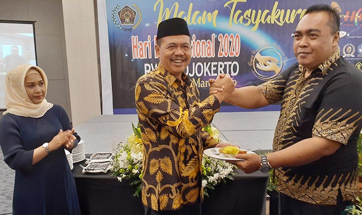 Ketua PWI Mojokerto saat memberikan potongan nasi kuning ke H. Pungkasiadi Bupati Mojokerto.