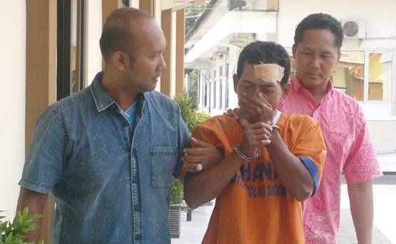 MANIAK: Tersangka Samidi ketika digiring petugas ke tahanan Mapolres Sidoarjo, Jum