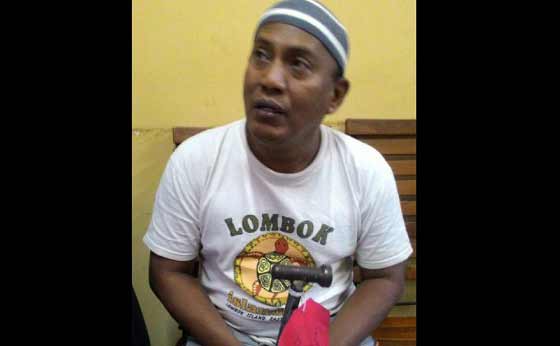 Tersangka bersama barang bukti palu yang digunakannya menghajar istri siri. foto: catur andy/BANGSAONLINE