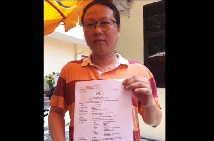 Korban menunjukan surat laporan ke Polda Jatim. (foto: rusmiyanto/BANGSAONLINE)