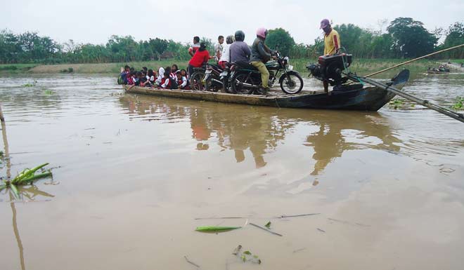 Para penumpang naik kapal perahu tambang untuk menyeberangi sungai bengawan solo