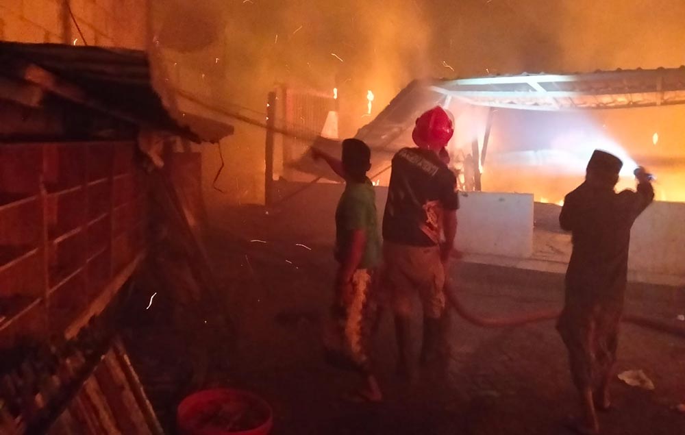 Petugas damkar saat berupaya memadamkan api yang membakar bangunan asrama.