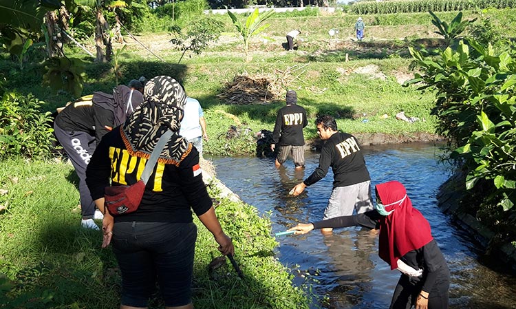 Aksi para relawan saat mengangkat sampah di Sungai Tempuran di Dusun Soko, Desa Menang, Kecamatan Pagu, Kabupaten Kediri. (foto: MUJI/ BANGSAONLINE)