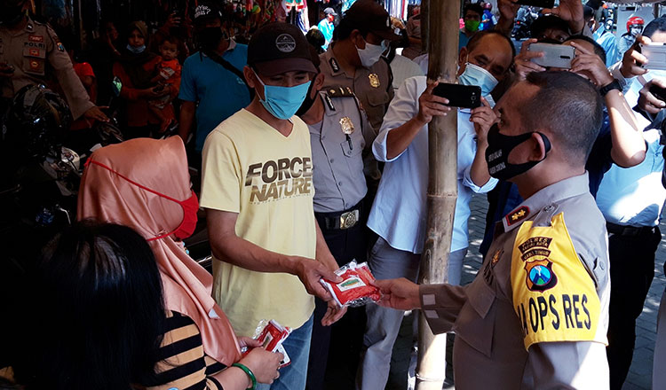 Kapolres Kediri Kota AKBP Miko Indrayana saat membagikan masker kepada para pedagang Pasar Selowarih. (foto: MUJI/ BANGSAONLINE)