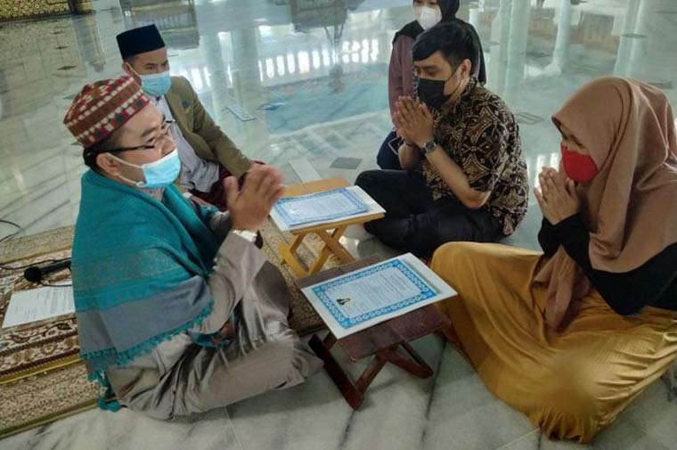 Nona Granita Gharisa dan Andri Marlino Januar Eka Putra usai proses ikrar dua kalimat syahadat yang dituntun oleh Imam Masjid Al-Akbar Surabaya, Imam Nasikh Hidayatullah di Masjid Nasional Al-Akbar Surabaya, Jumat (16/4/2021). foto: MMA/ BANGSAONLINE.com