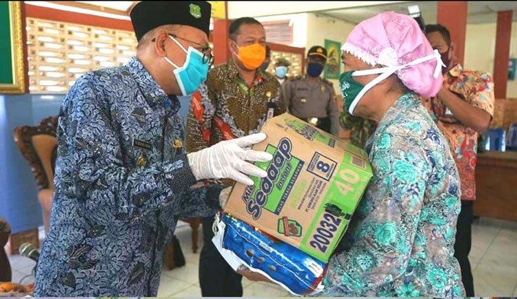 Bupati Sumenep saat menyerahkan bantuan sembako kepada masyarakat terdampak Virus Covid-19 di Kecamatan Gapura dan Kecamatan Dungkek.
