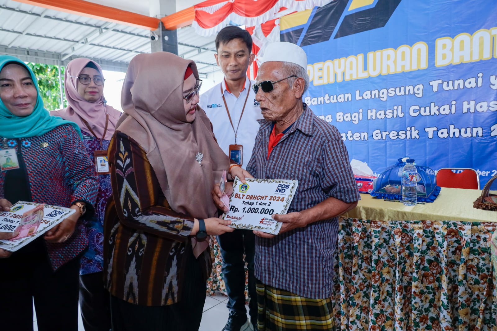 Plt Bupati Gresik Aminatun Habibah menyerahkan bantuan BLT DBHCHT kepada warga kurang beruntung. Foto: Ist.