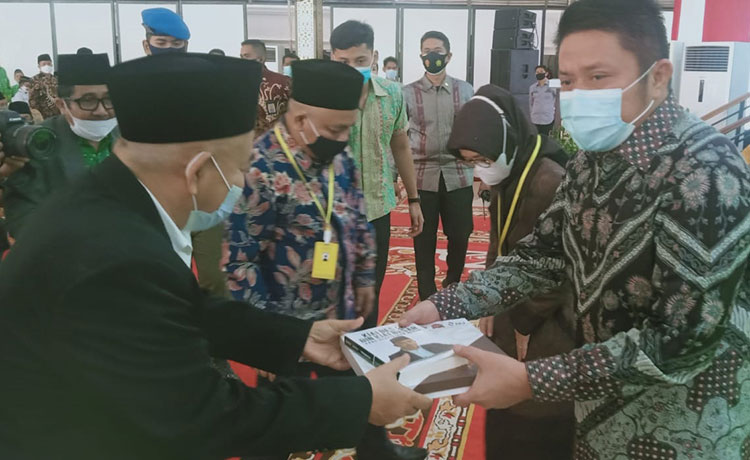 Kiai Asep saat memberikan buku "Kiai Besar Bin Kiai Besar" kepada Gubernur Sumsel H. Herman Deru.