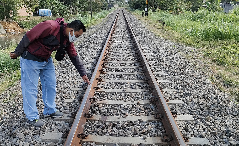 Seorang warga yang menunjukkan lokasi Siti Rochani saat tersambar KA Malabar. Foto: MUJI HARJITA/BANGSAONLINE.com