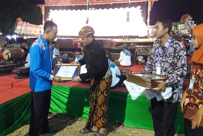 Ketua KNPI Pacitan, Muhammad Rofiqin saat menyerahkan sertifikat kepada perwakilan dalang. 