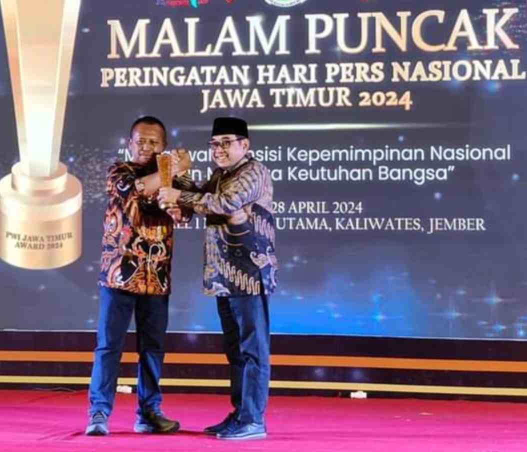 Arif Afandi ketika menerima penghargaan dari Ketua PWI Jatim Lutfil Hakim. Foto: dok pribadi