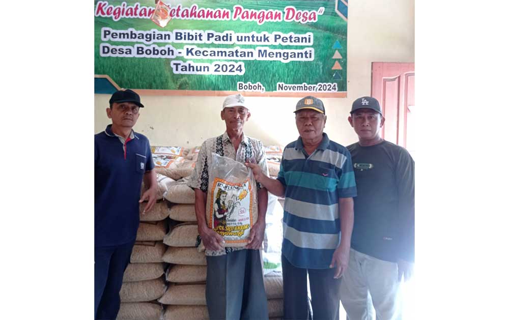 Kades Boboh, Abdul Majid (dua dari kanan) menyerahkan bibit padi kepada petani. Foto: Ist.
