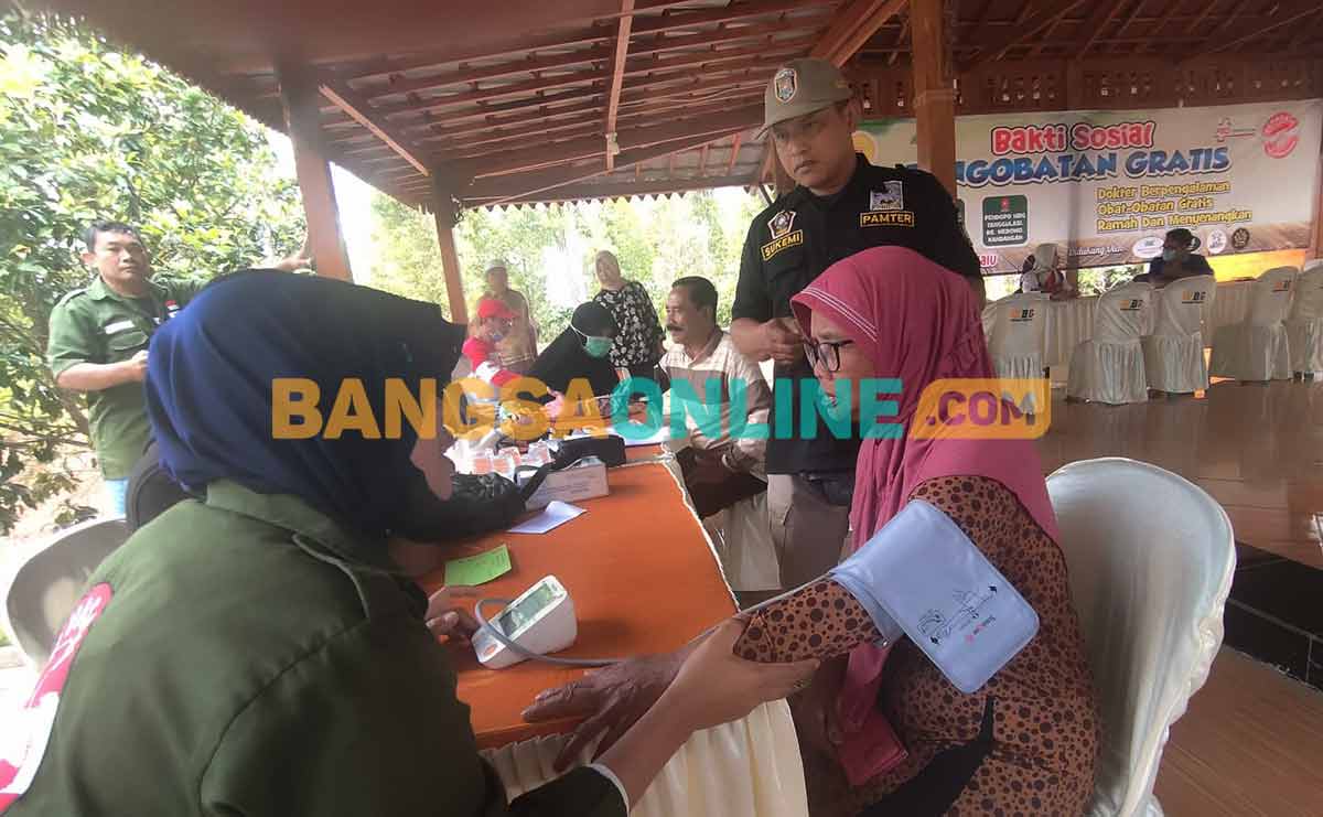 Ketua Yayasan Pare Penuh Kasih, Marijem, saat memeriksa tekanan darah salah satu warga. Foto: MUJI HARJITA/BANGSAONLINE
