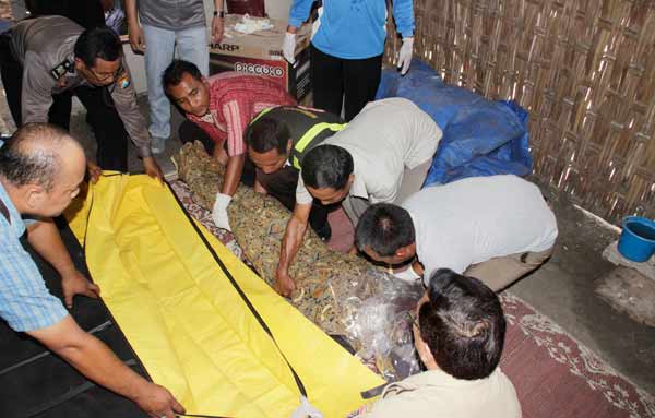 Petugas saat mengevakuasi jenazah korban. foto: zainal abidin/BANGSAONLINE