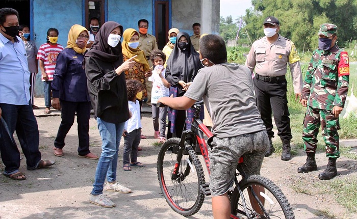 Ketua TP PKK Kota Kediri Ferry Silviana Abu Bakar saat berbincang dengan Saiful yang langsung mencoba naik sepedanya. foto: ist.