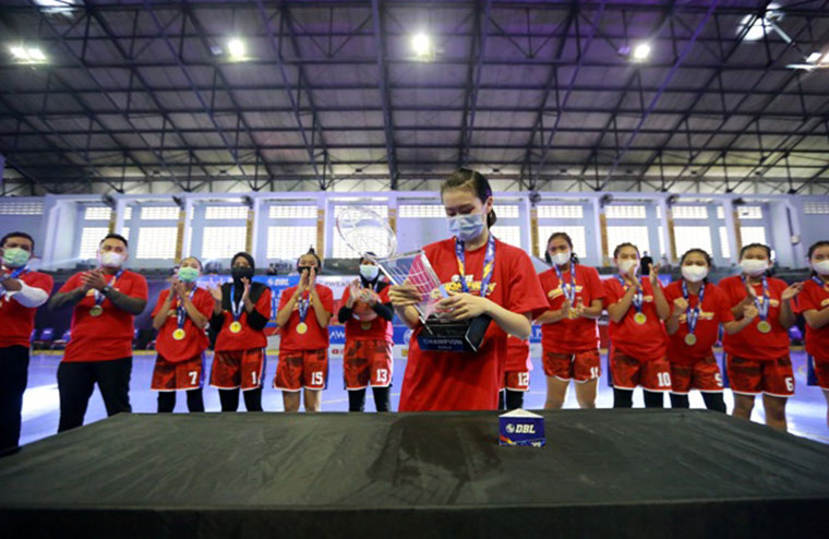 Kapten Tim Putri SMAN 5 Mataram mewakili rekan-rekannya mengambil trofi champion DBL 2021 West Nusa Tenggara Series, setelah memenangi laga final atas SMAN 1 Narmada di GOR 17 Desember Turida, Jumat (26/2). foto: ist.