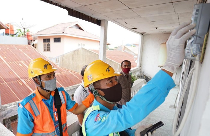 Petugas PLN melakukan penambahan daya kepada salah satu pelanggan.