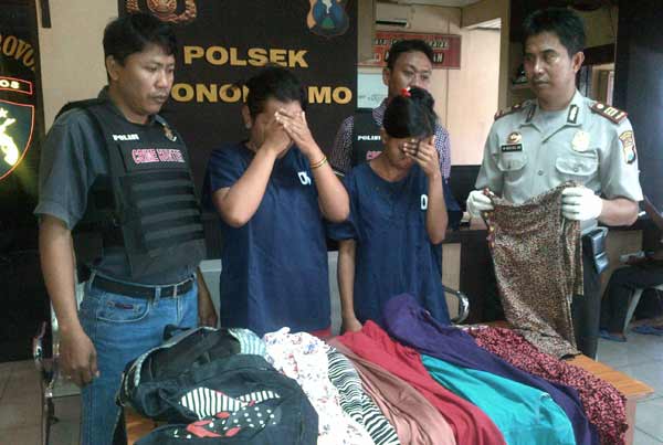 Yayuk dan Sundari, diapit petugas beserta baju curiannya. foto: rusmiyanto/BANGSAONLINE