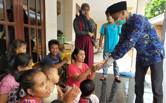 Agus Mulyanto selaku Kepala Desa sekaligus Ketua Tim Gugus Tugas Penanganan Covid-19 Desa Karang Pao saat membagikan masker kain kepada warga setempat.