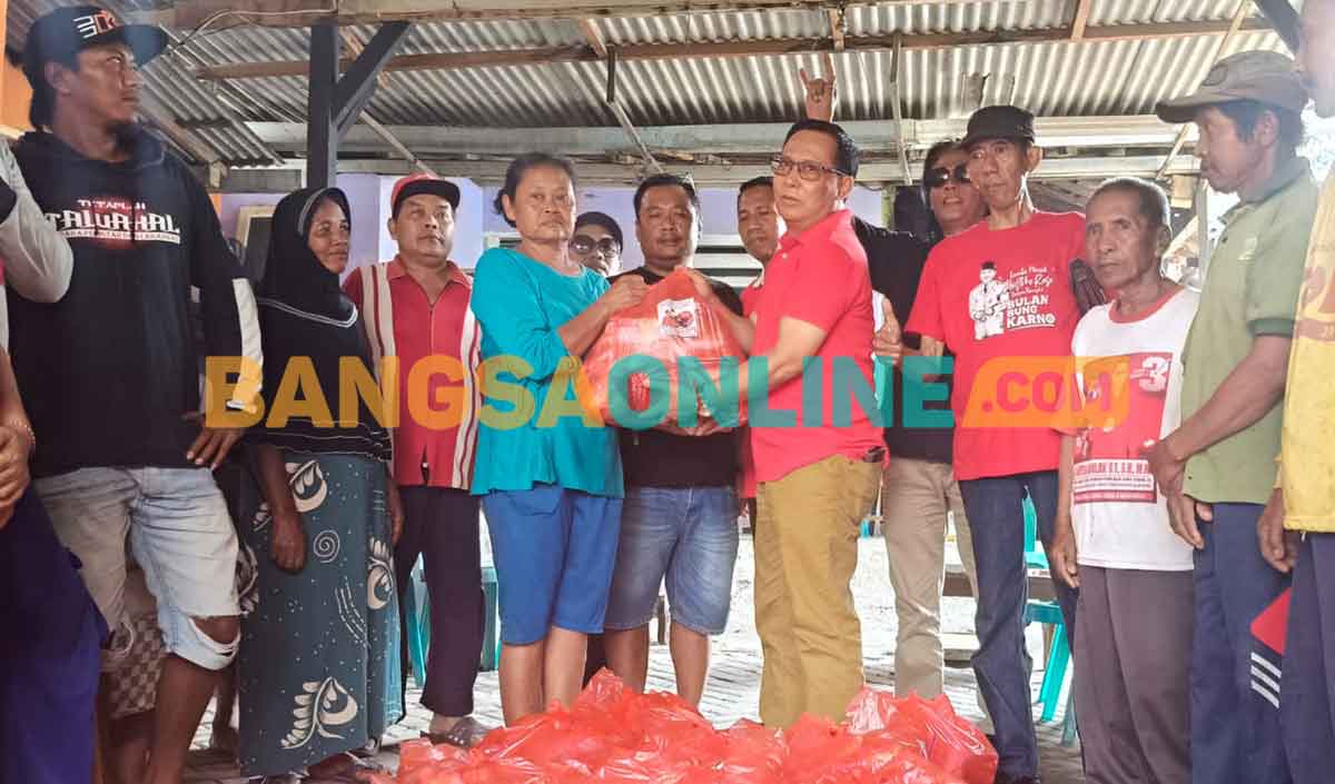 Ketua DPC PDIP Kabupaten Kediri, Murdi Hantoro, saat menyerahkan bantuan kepada salah satu warga korban bencana di Desa Besowo. Foto: MUJI HARJITA/BANGSAONLINE