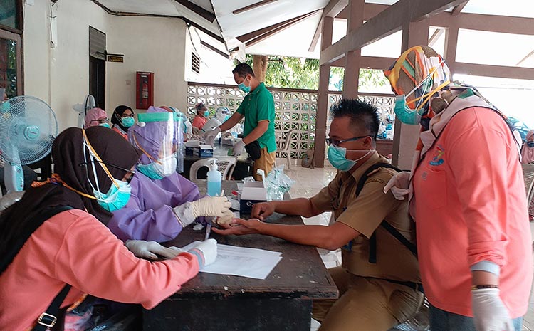 Ainul Yaqin, S.E., M.M., Sekcam Kamal didampingi Hj. Nur Khotibah, Kapus Kamal saat melakukan rapid test di Kantor Kecamatan Kamal yang dilaksanakan Tim Covid-19 Hunter Jatim bersama Dinkes Bangkalan, Senin (8/6).