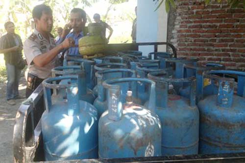 OPLOSAN. Kapolsek Buduran Kompol Sutopo Prayitno menunjukkan barang bukti (BB) elpiji oplosan dari penggerebekan. foto: nanang ichwan/BANGSAONLINE
