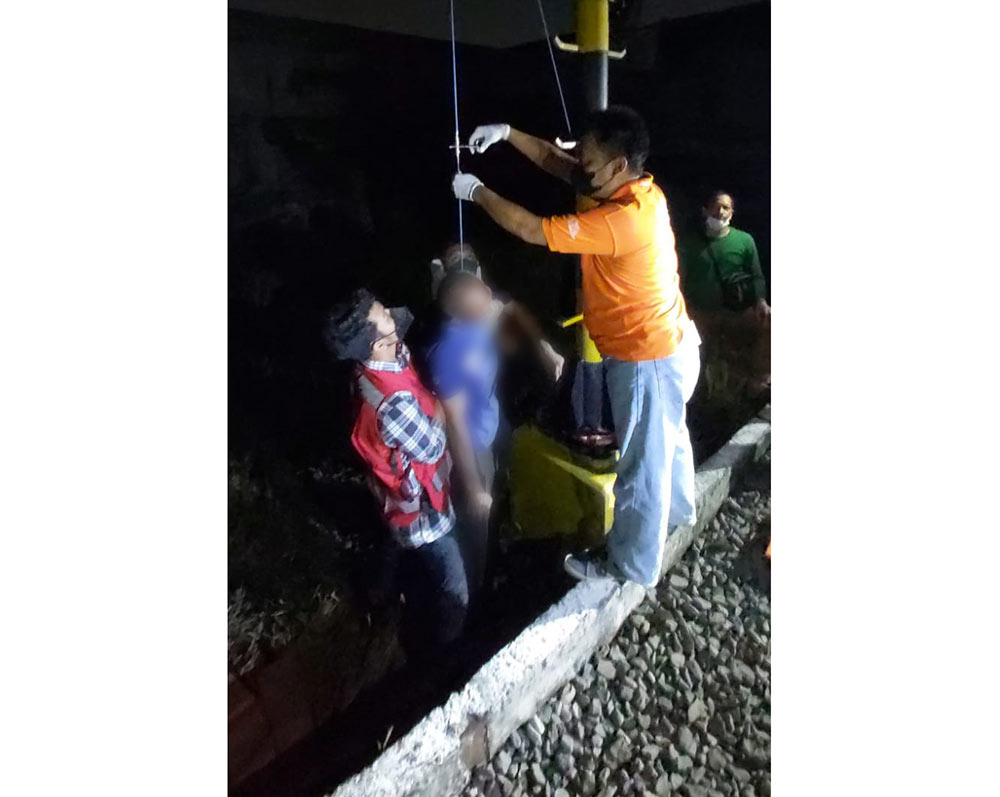 Petugas saat mengevakuasi korban bunuh diri di tiang signal kereta api antara stasiun Tandes dan Kandangan.
