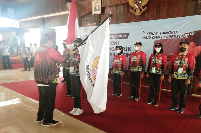 Plt Bupati Marhaen memberikan panji KONI saat melepas para atlet untuk bertanding di Porprov VII Jatim 2022. foto: BAMBANG DJ/BANGSAONLINE