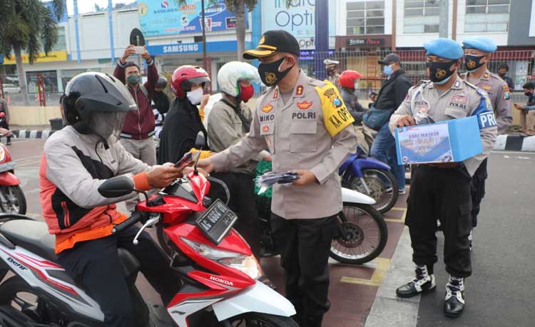 Kapolres Kediri Kota, AKBP Miko Indrayana saat membagikan masker kepada pengguna jalan di pemberhentian lampu merah Alun-Alun Kota Kediri, Selasa (22/9). (foto: ist.)