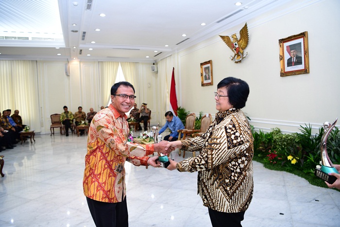 Menteri LHK Siti Nurbaya menyerahkan penghargan kepada Direktur Produksi PG I Ketut Rusnaya. 