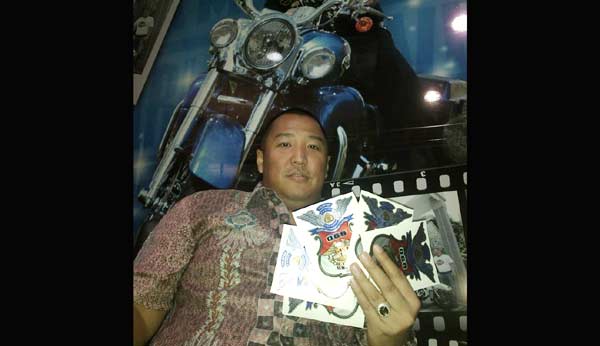 Tonny menujukan stiker anggota HDCI. foto: rusmiyanto/ BANGSAONLINE