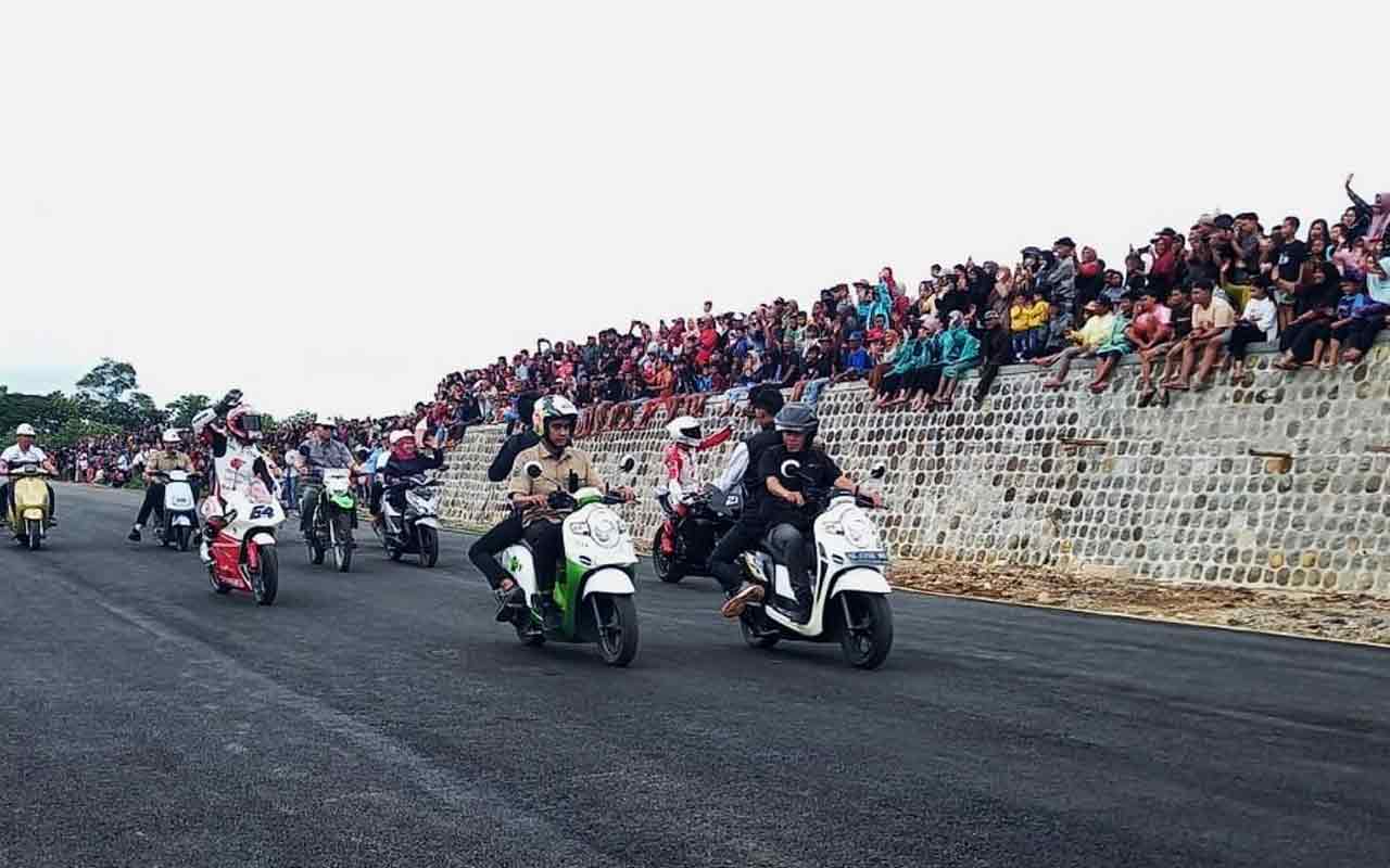 Khofifah Indar Parawansa bersama Mario Aji pembalap Moto GP 2 dan pembalap Adenanta saat melintasi Sirkuit Parang Magetan. Foto: Ist.