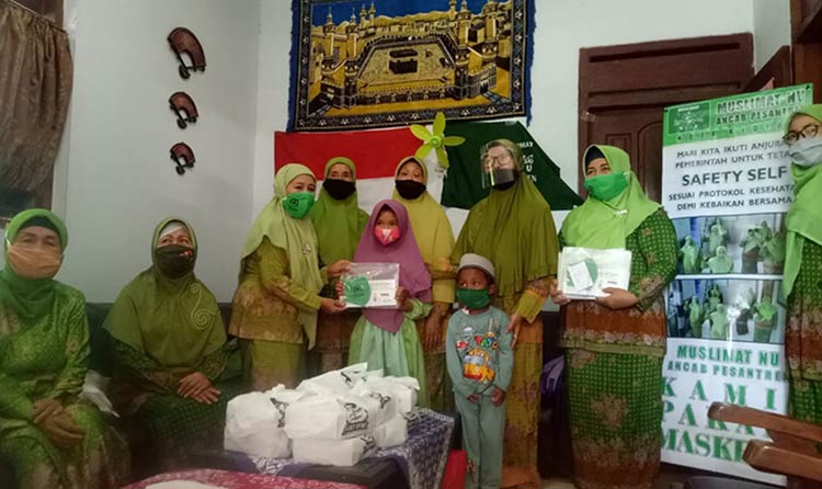 Ketua PAC Muslimat NU Kecamatan Pesantren Kota Kediri, Siti Asiyah dan jajaran pengurus saat membagikan masker dan bantuan kepada anak yatim. (foto: ist).