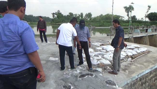 Tumpukan limbah diduga beracun di pinggir Sungai Afur Desa Budugsidorejo, Kecamatan Sumobito, Kabupaten Jombang saat diambil sampelnya oleh Polda dan BLH Jatim, Kamis (19/05). foto: romza/ BANGSAONLINE