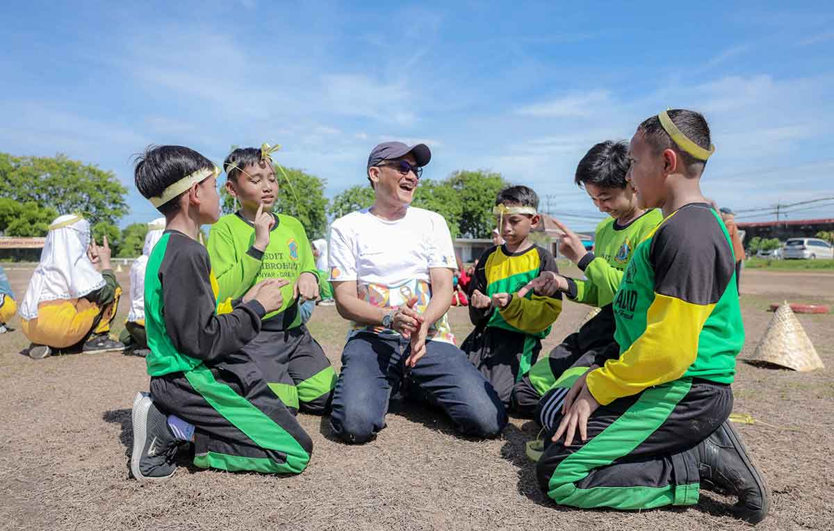 Kebersamaan karyawan Freeport Indonesia dengan peserta Hari Anak Sedunia 2024 saat memainkan salah satu permainan tradisional, cublak-cublak suweng. Foto: Ist