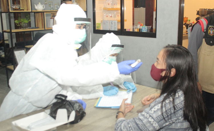 Petugas menunjukkan hasil rapid test salah seorang pengunjung kafe di Kota Blitar.