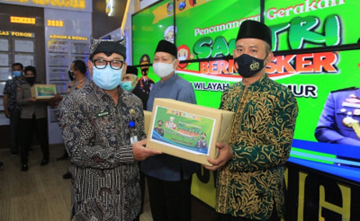 Kombes Arman Asmara Syarifudin menyerahkan 25 ribu masker kepada perwakilan pondok pesantren di Banyuwangi.