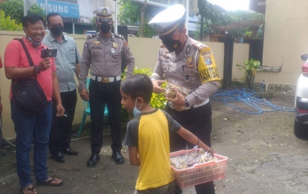 Kasatlantas Polres Blitar AKP I Putu Angga Feriyana saat memborong dagangan peyek yang dijual Tangguh.