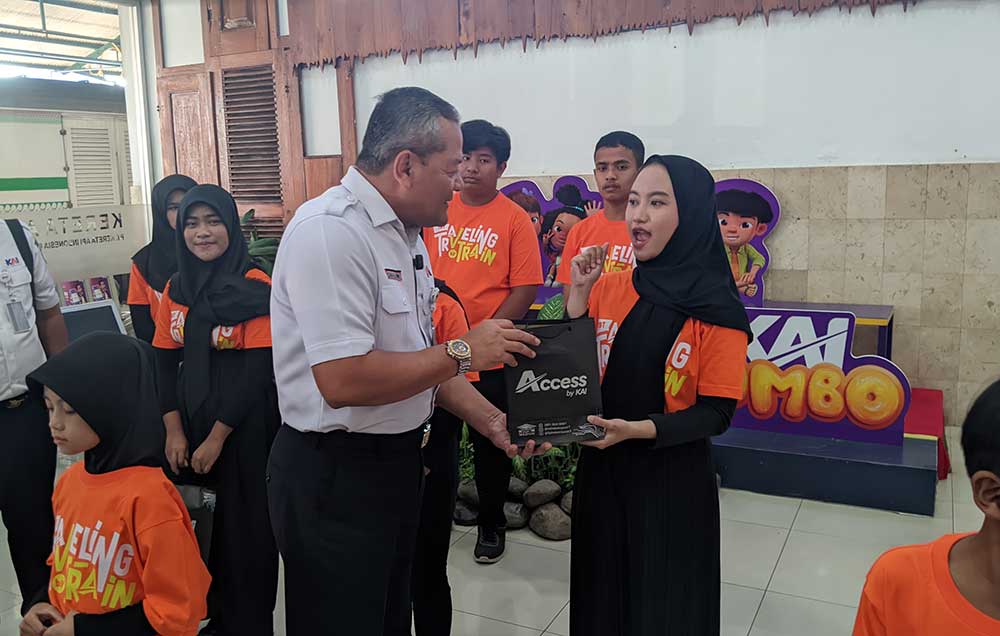 VP PT KAI Daop 7 Madiun, Suharjono, saat memberikan cenderamata kepada anak disabilitas. Foto: HENDRO SUHARTONO/ BANGSAONLINE